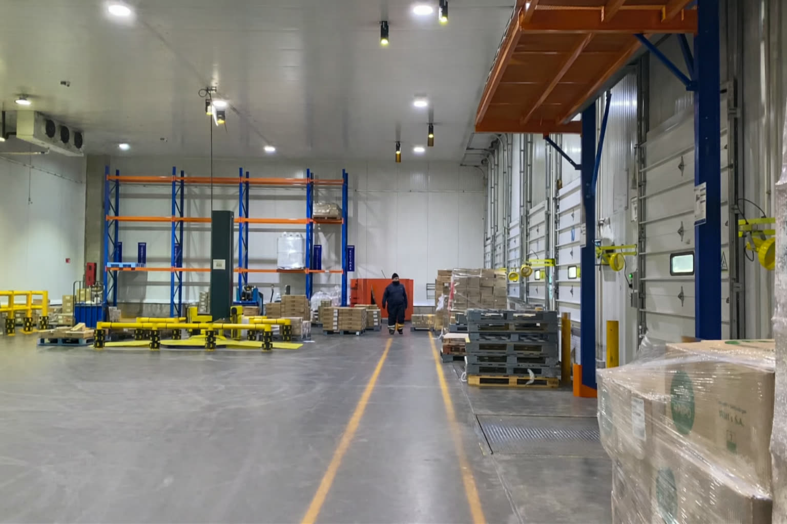 Pasillo de bodega industrial con demarcación proyectada en el piso